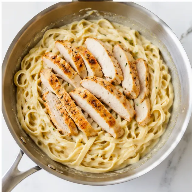 Step 4: Tossing pasta with sauce and chicken