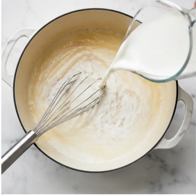 Step 2: Whisking in hot milk to create bechamel