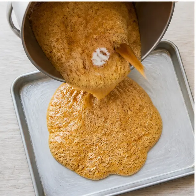 Step 3: Adding baking soda and spreading the foaming toffee on the pan.