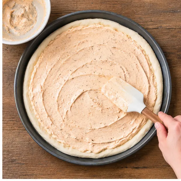 Step 2: spreading a smooth cream cheese and taco seasoning blend over the dough
